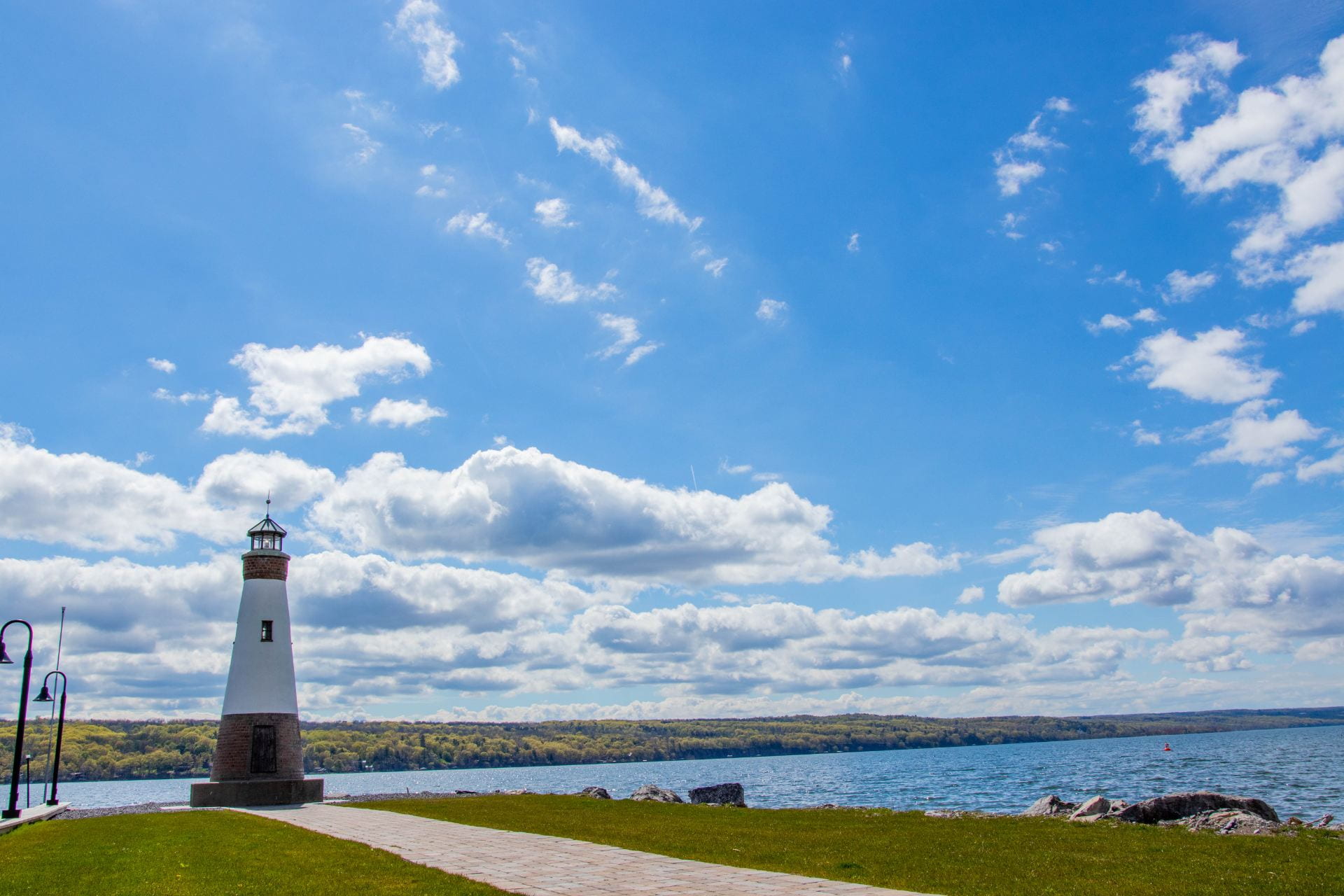 An image of the Myers Point Lighthouse in Lansing with a blue sky and clouds behind it.